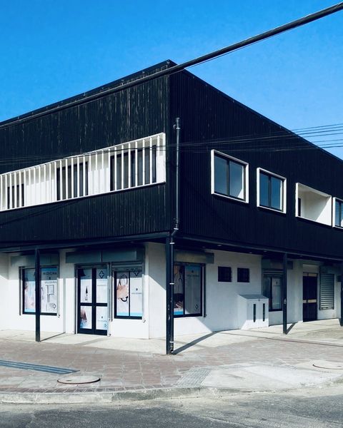 Fachada del Centro Médico Carampangue en Monsalve 102: edificio de dos pisos revestido en madera oscura, en la esquina con República, con un taxi colectivo amarillo.